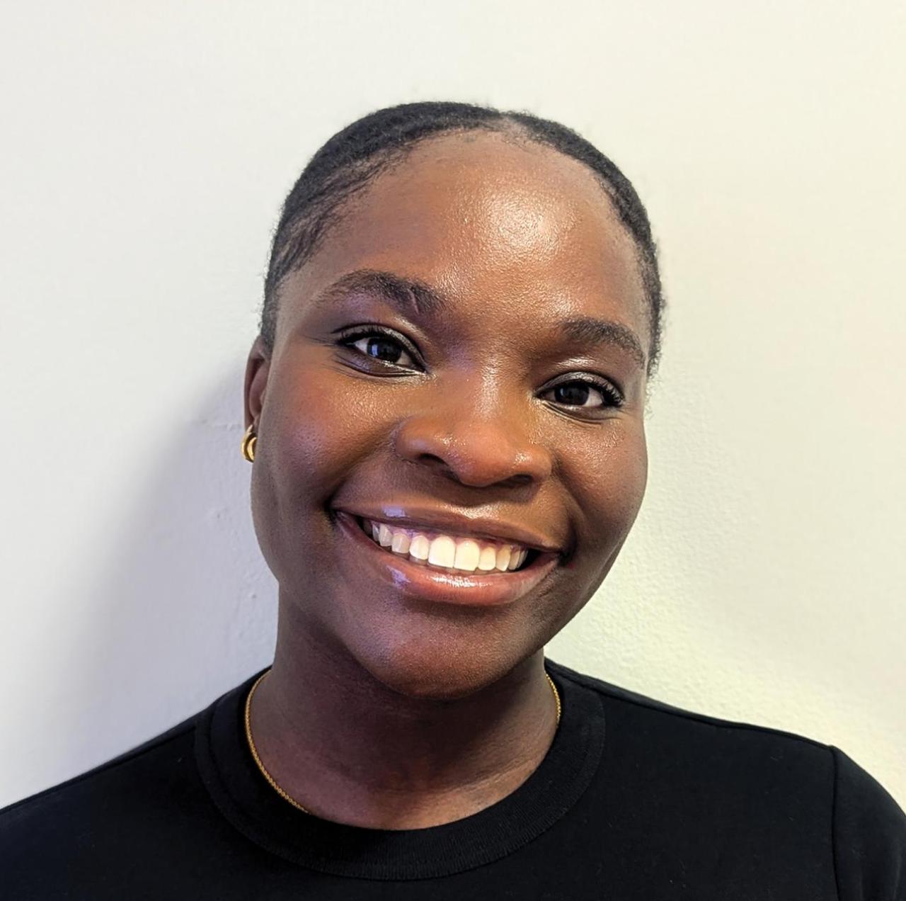 Portrait of Alicia Chime smiling against a plain background.