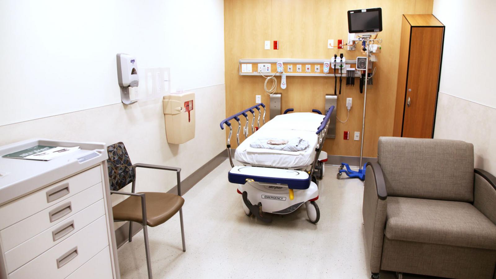 A hospital room with a bed and medical equipment.