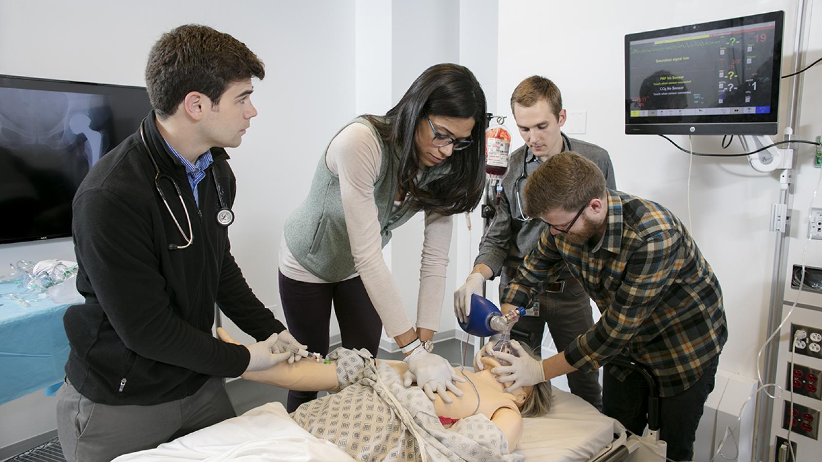 Medical students working with surgical manikin.