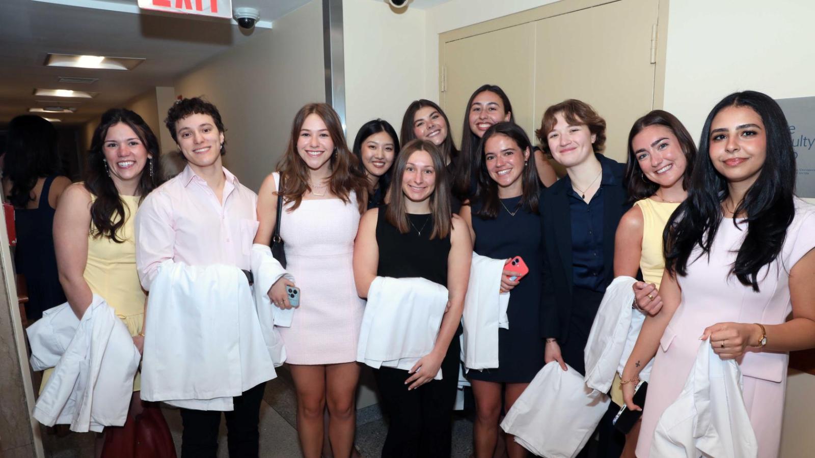 Doctor of Physical Therapy students pose together holding white coats during a Columbia University white coat ceremony.