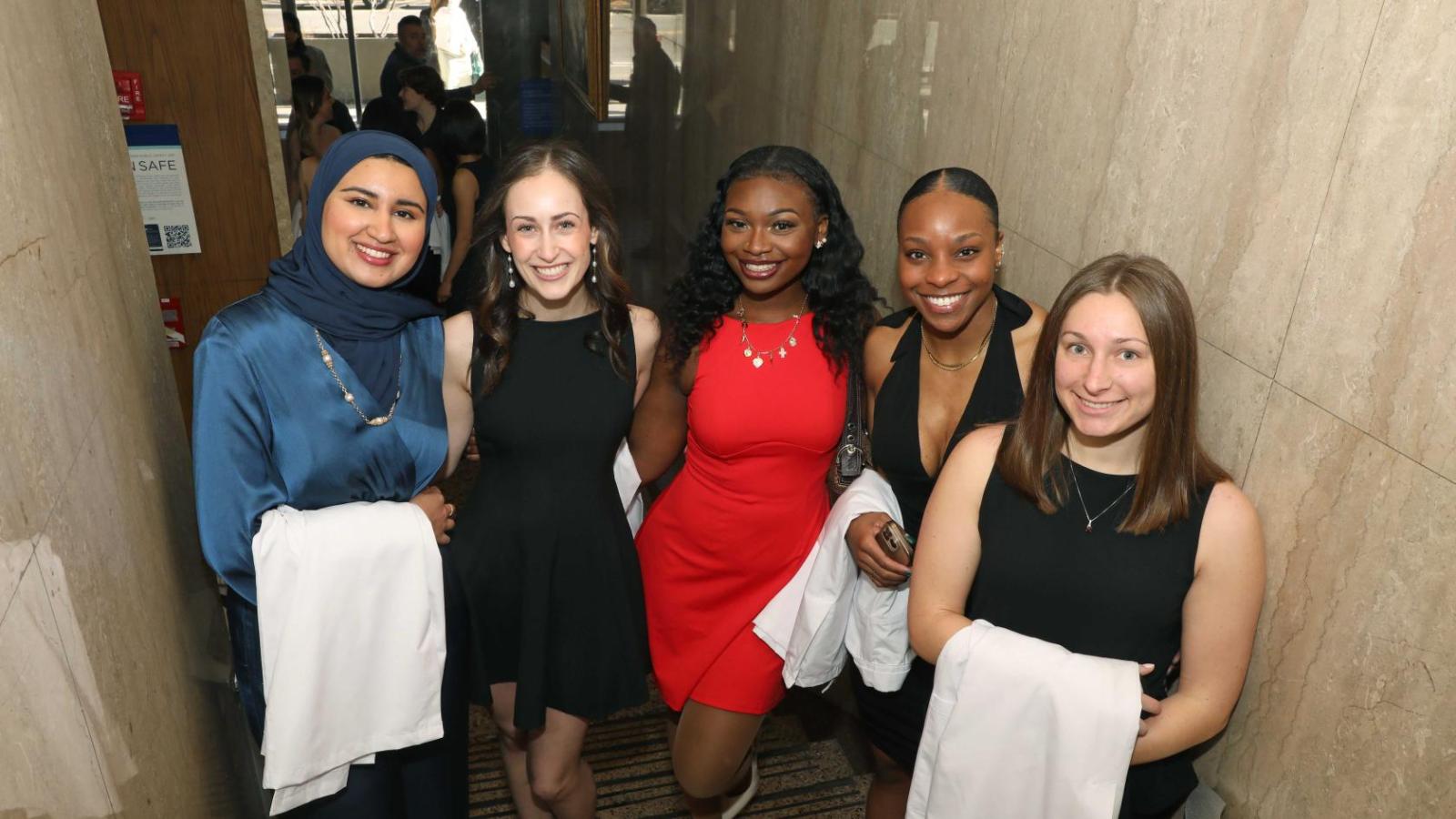 Doctor of Physical Therapy students pose together holding white coats during a Columbia University white coat ceremony.