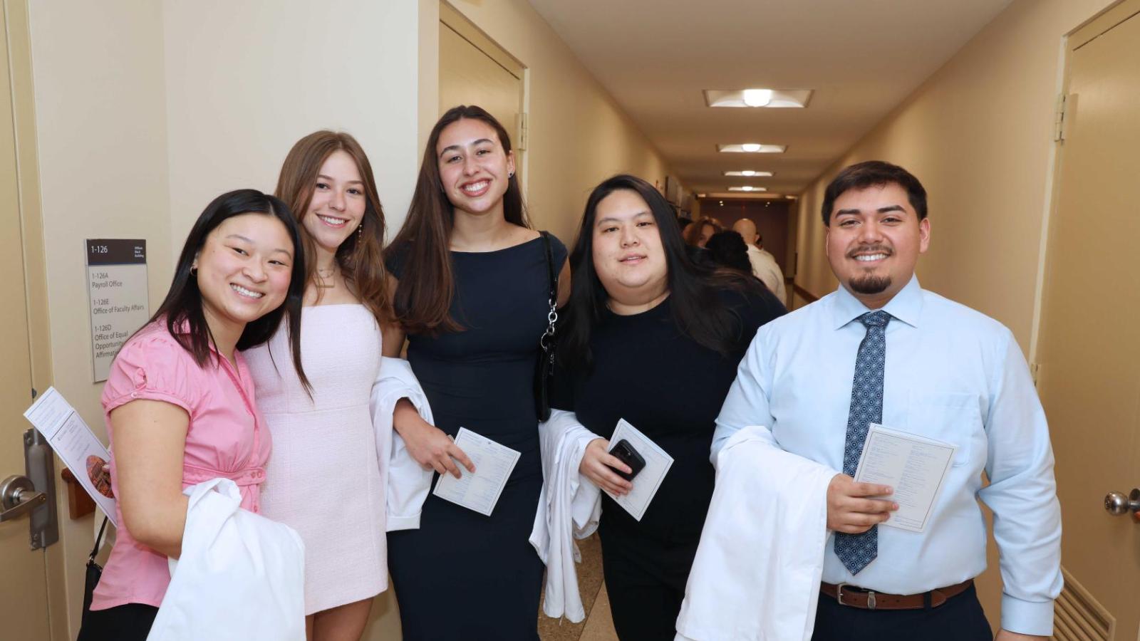 Doctor of Physical Therapy students pose together holding white coats during a Columbia University white coat ceremony.