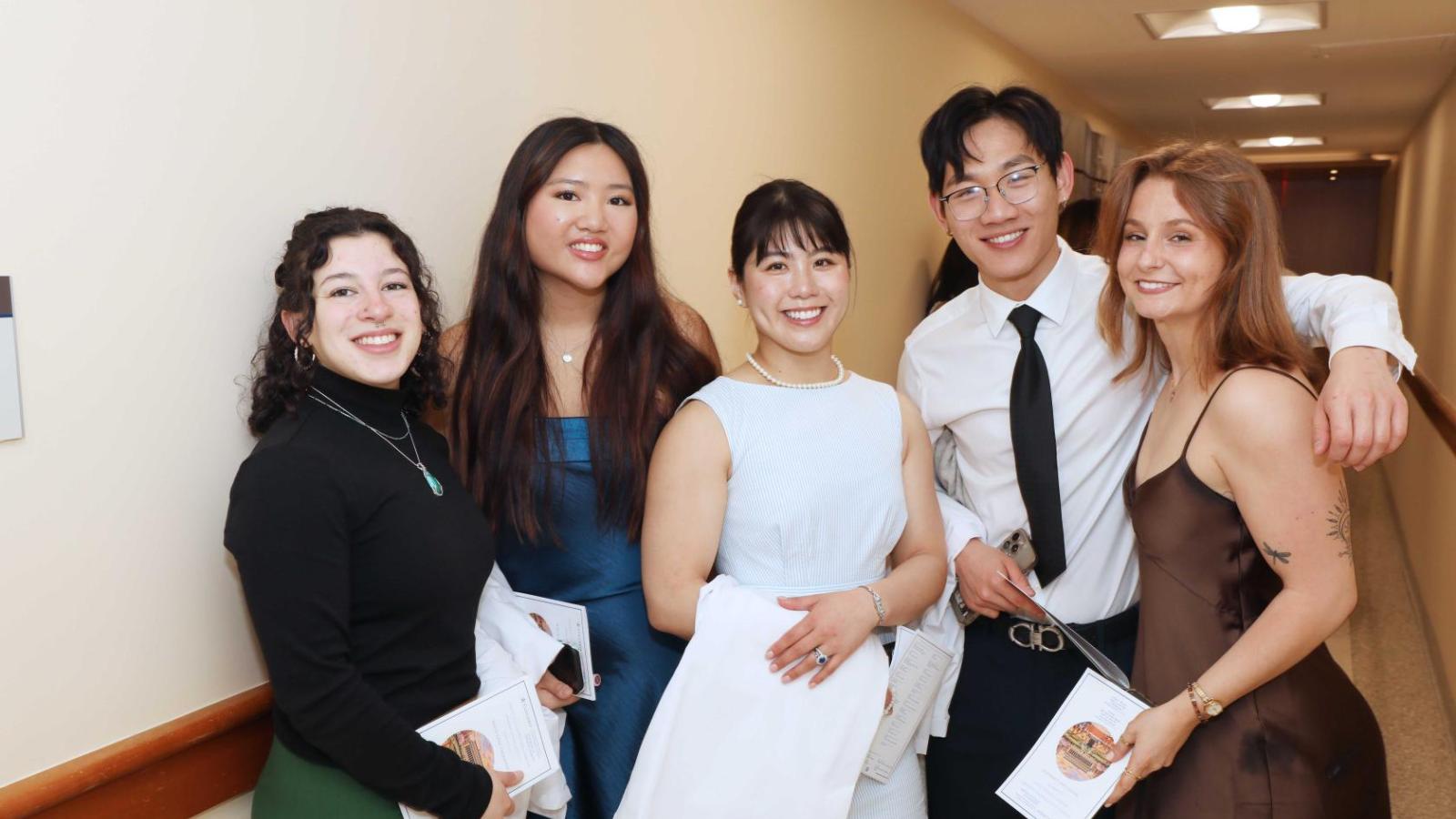 Doctor of Physical Therapy students pose together holding white coats during a Columbia University white coat ceremony.