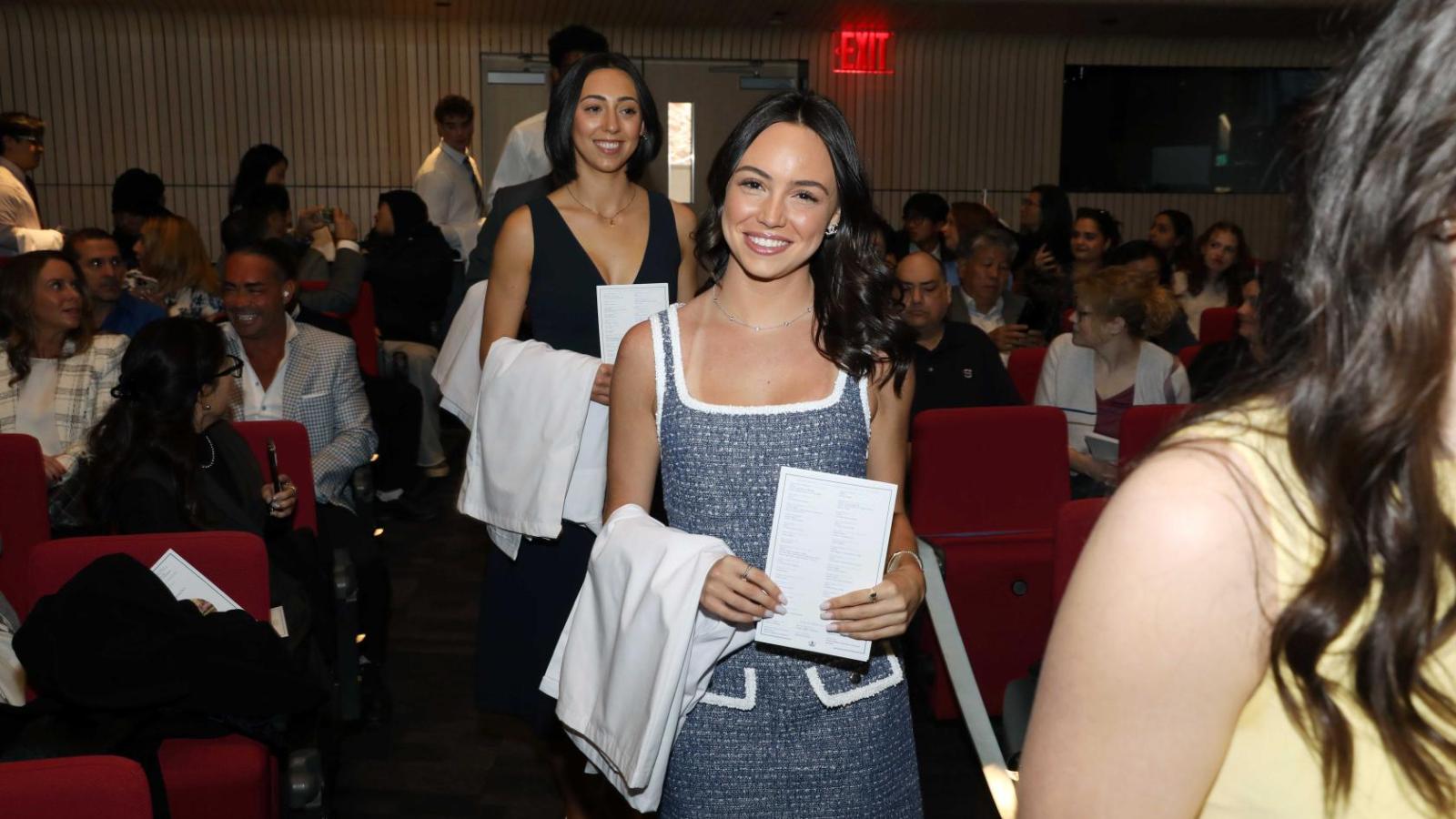 Doctor of Physical Therapy students walk down the aisle holding white coats during a Columbia University white coat ceremony.