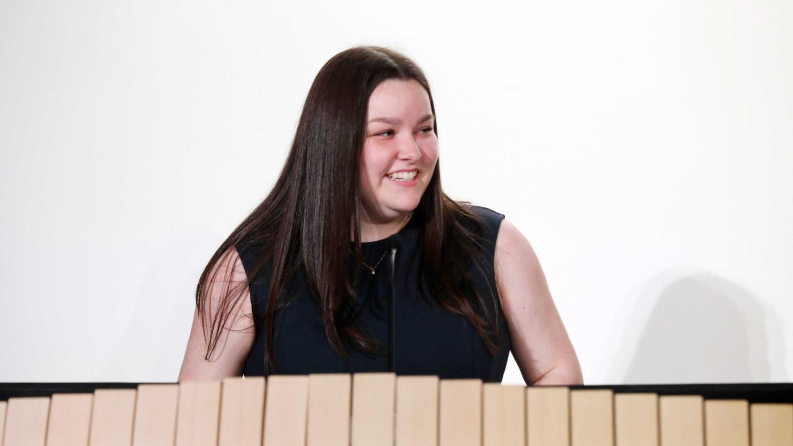 Student addresses attendees at a podium during a Columbia University white coat ceremony.