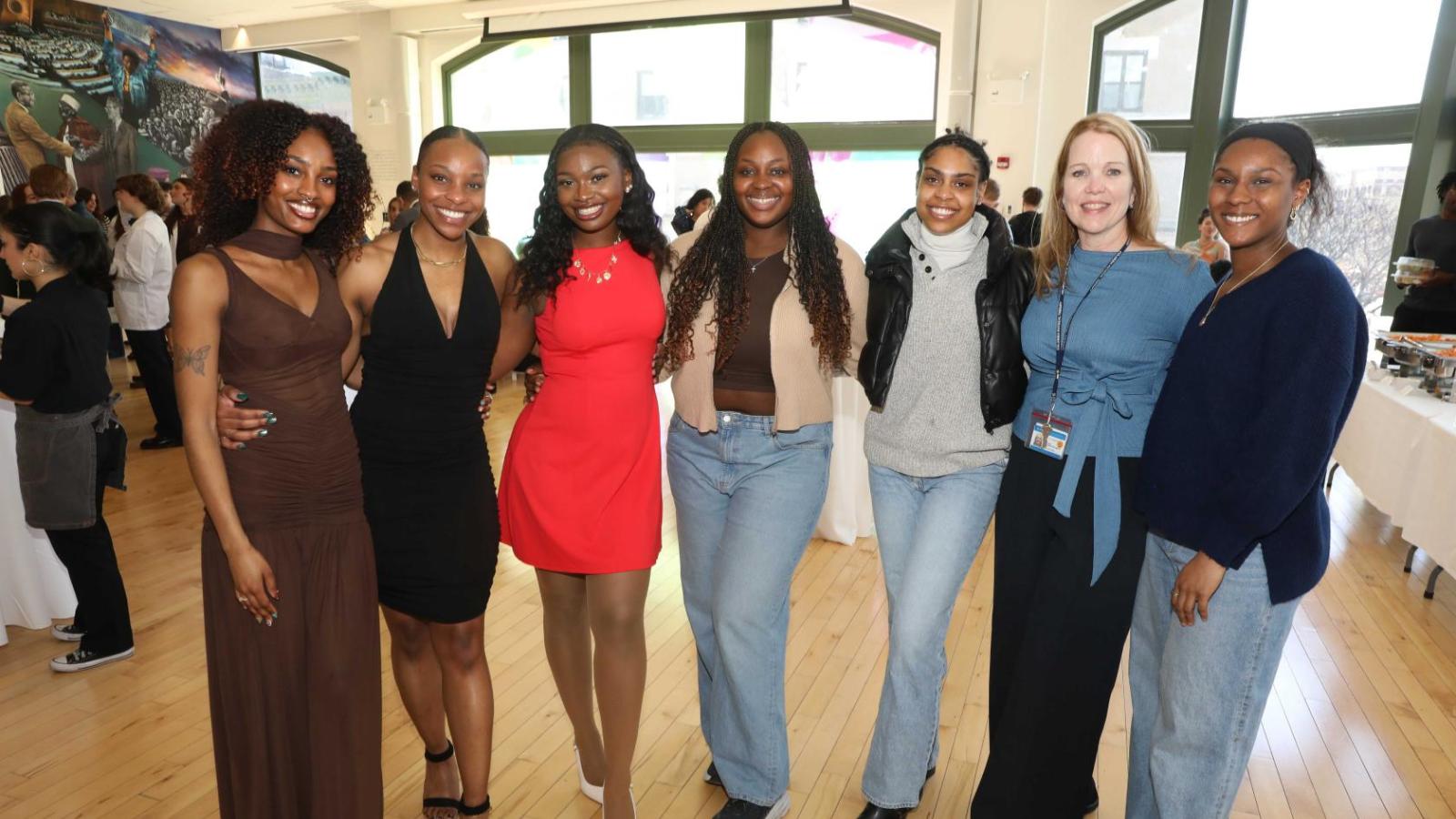 Columbia physical therapy students in white coats pose with a faculty member during the white coat ceremony reception.