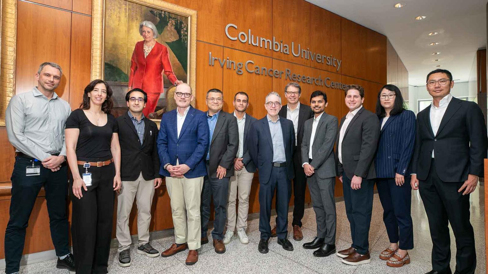 A group of researchers posing in the lobby of the Columbia University Irving Cancer Research Center.