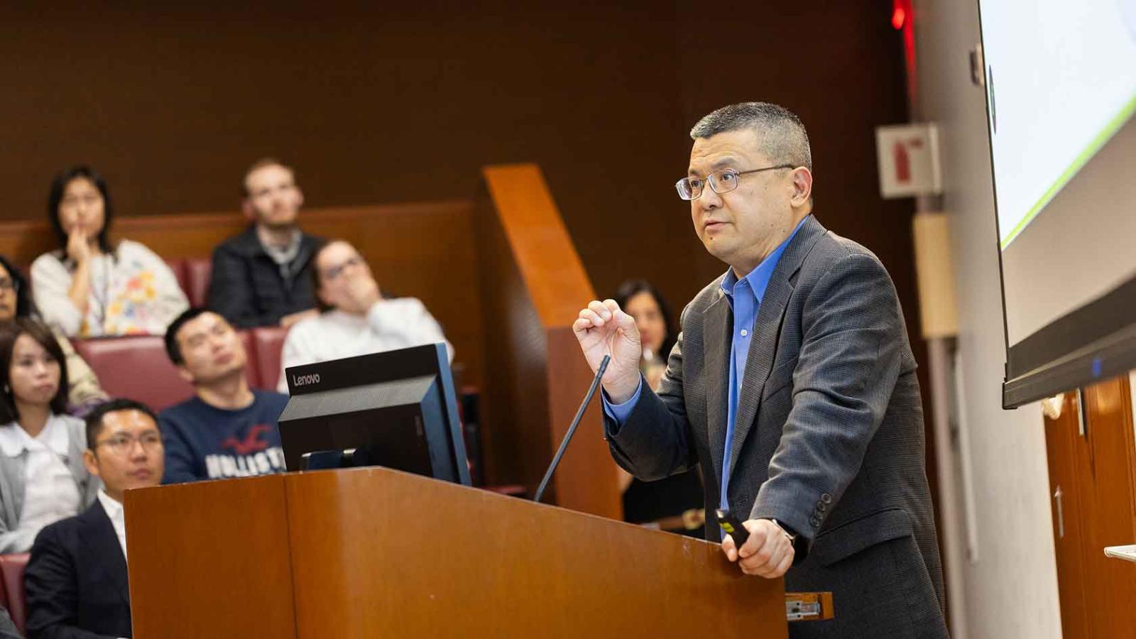 A speaker delivers a keynote presentation at a podium