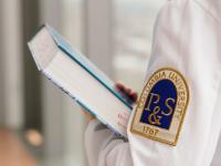 Medical student holds a textbook.