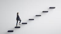 A conceptual image of a woman climbing the career ladder