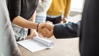 Two people shaking hands in an office