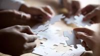 Several people solving a puzzle together