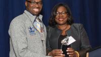 A male medical student accepts an award from Dr. Hilda Hutcherson at Columbia's BALSO event.