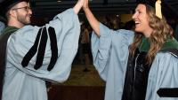 Two Class of 2017 Columbia medical school graduates give each other a high five at Commencement.