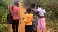 A medical student walks with three people in Kitui.