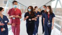 Seven clinicians walk down a hallway