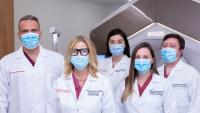 The Department of Radiation Oncology Chair and faculty standing in front of Ethos radiation therapy equipment.