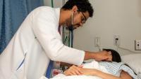 Resident checking on patient with stethoscope