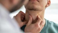 Doctor examining patient's throat at clinic