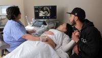Clinician performing an ultrasound on a pregnant patient.