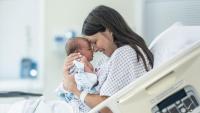 A mother holding her baby in a hospital bed