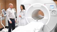 Doctor speaking with a man beside an MRI scanner