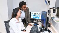 Two women look at radiology images on a computer