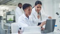 Two scientists using a laptop in a laboratory.