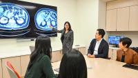 Dr. Kang points to radiology images on a screen