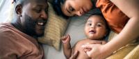 Parents and baby on the bed overhead view